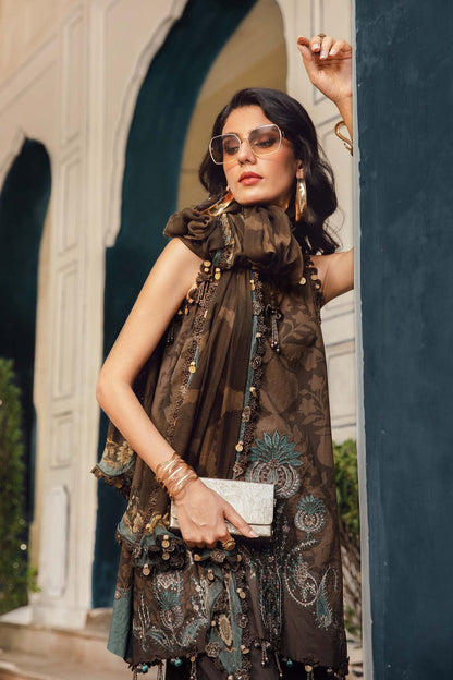 Woman in an ornate dress with sunglasses and a clutch, standing in front of a building.